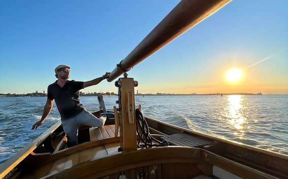 Paseo en barco de madera por la laguna de Venecia al atardecer